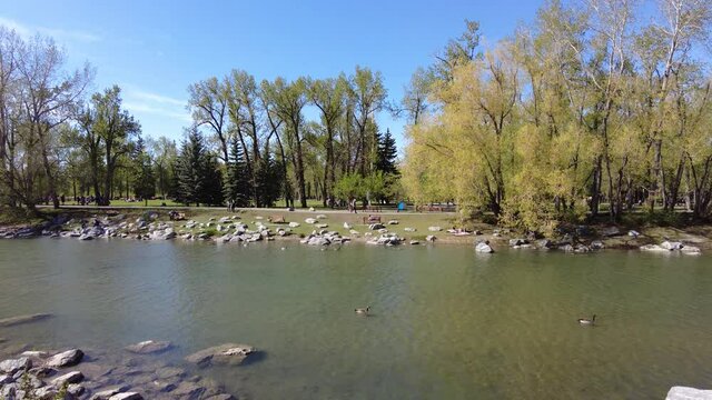 People Walking In The Distance On A Hot Summer Day In Calgary Downtown Along The Bow River Pathway. Popular Running And Biking Spot In Calgary, Alberta Canada