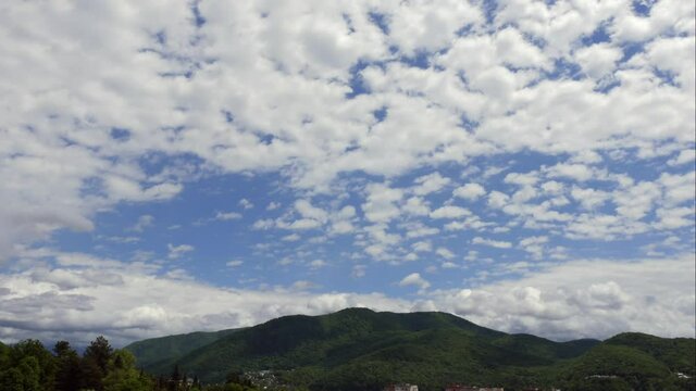 Blue sky white clouds over the mountains. Puffy fluffy white clouds. Cumulus cloud scape timelapse. Summer blue sky time lapse. Dramatic majestic amazing blue sky. Soft white clouds form. Clouds time