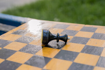 One chess piece of the black queen is lying on the chessboard