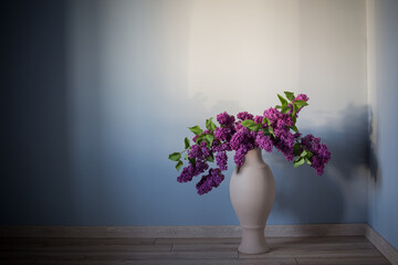 lilac flowers in vase on wooden floor