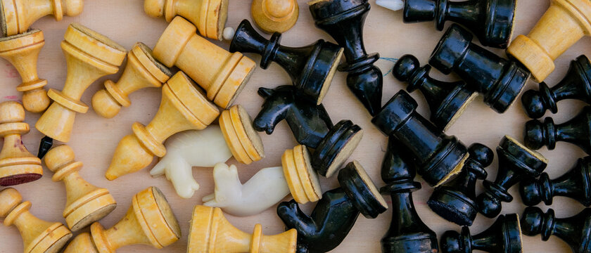 The whole set of black and white chess pieces are in the box in a different order