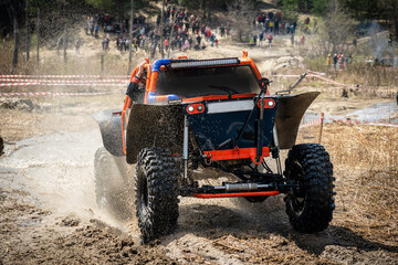 Offroad vehicle makes splashes of dirty water at sunny day