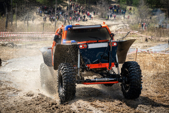 Offroad vehicle makes splashes of dirty water at sunny day