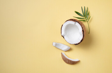 Concet of eco friendly flat lay. Fresh coconut and slices  on yellow  background. Healthy and vegan food. Top view and copy space