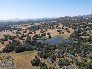 Fototapeta na wymiar Aerial view of small lake in the valley, between farmland and forest in the town of Julian, east of San Diego, California, USA