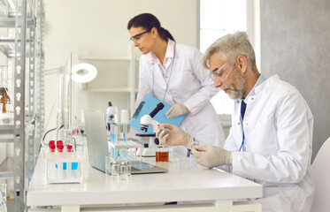 Medical scientists working in science laboratory and analyzing samples using modern lab equipment....