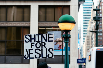 Banner with the text Shine for Jesus besides street lamp in New York City