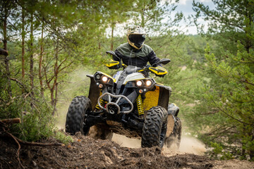 Professional quad biker rides in forest. Quad racing, ATV 4x4