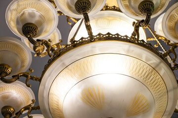 A beautiful vintage style chandelier hangs on the ceiling and shines, close-up.