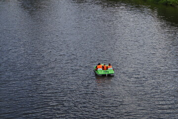 family rides on the river on a catamaran on a summer day, top view from afar