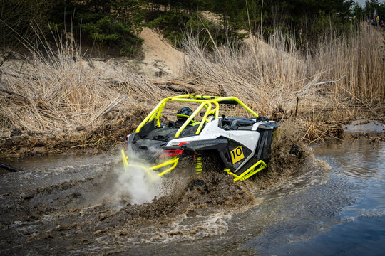 Cool view of active 4x4 vehicle driving in mud and water. ATV rider