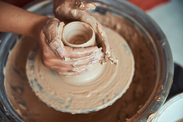 Female hands making clay pot in pottery workshop