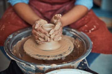 Female hands making earthenware pot in pottery workshop