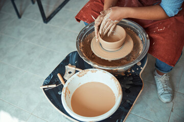 Female ceramist making clay bowl in pottery workshop