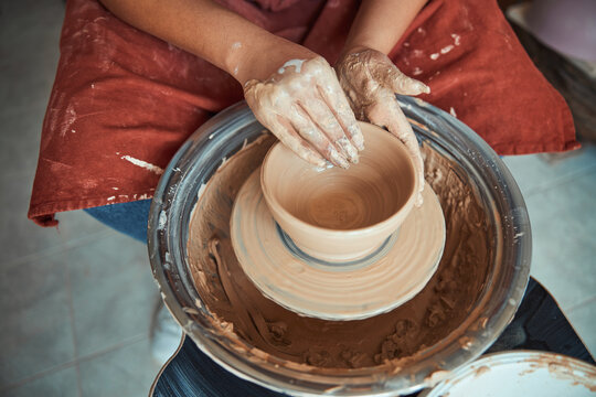 Female potter hands making clay bowl in pottery workshop