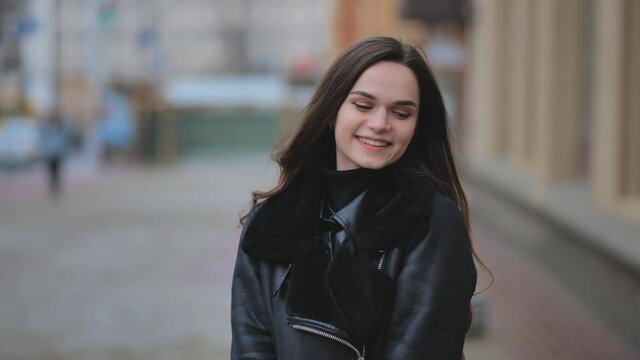 Portrait of a posing happy girl in the city in early spring.