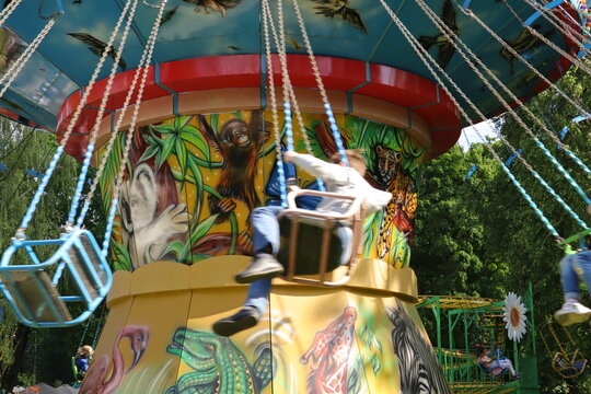 summer attraction in the park children ride a carousel