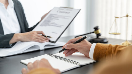 Lawyer with lawsuit meeting with client discussing with contract agreement at courtroom.