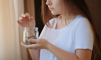 Turkish coins glass jar in woman hands. The paper currency of Turkey. Financial crisis and saving...