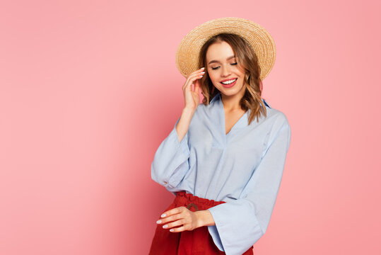 Pretty woman in sun hat posing on pink background