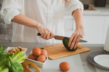 Beautiful girl in the kitchen prepares healthy food