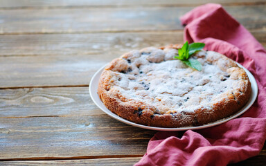 Piece of homemade simple pie with fresh red raspberries and black mulberry on a dark wooden rustic background. Summer berry dessert. Sugar powder.