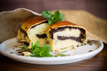 roll with poppy seeds inside on a wooden table.