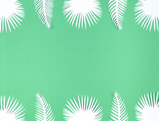 Fototapeta na wymiar Tropical paper leaves on green background, flat lay with copy space.
