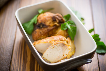 baked chicken fillet pieces with spices and herbs, in a ceramic form