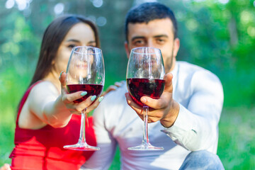 happy couple having fun in the park, couple drinking red wine in the park