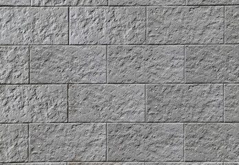 Texture of a decorative stone wall made of gray rectangular blocks - obrazy, fototapety, plakaty