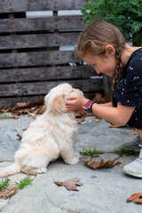 Little Girl Playing With Golden Retriever Puppy