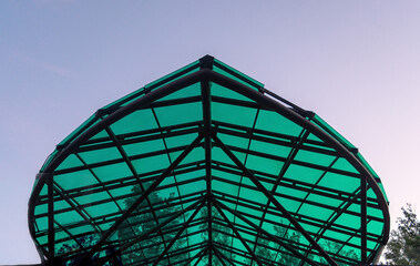 The corner of the canopy above the entrance to the city park against the sky.