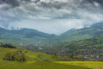 Fototapeta premium Low dramatic clouds over the mountain village