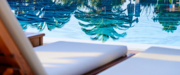 Blank sunbeds and swimming pool in luxury resort