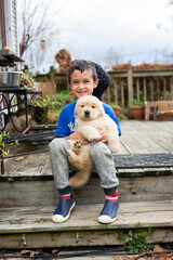 Little Boy Holding Golden Retriever Puppy
