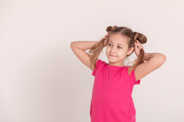 happy child on a white background. a girl in a pink T-shirt and pants.