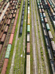 Freight trains on railway tracks. Aerial drone top view. Sunny spring day.