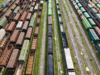 Freight trains on railway tracks. Aerial drone top view. Sunny spring day.