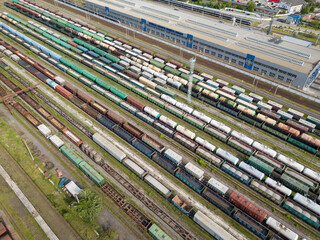 Freight trains on railway tracks. Aerial drone top view. Sunny spring day.