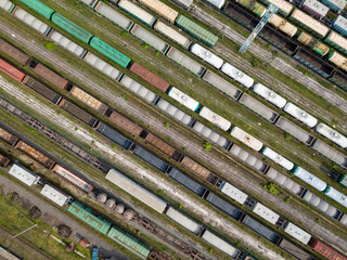 Freight trains on railway tracks. Aerial drone top view. Sunny spring day.