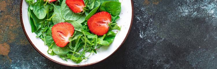 green salad strawberry leaves salad mix arugula, spinach organic healthy food meal snack copy space food background rustic. top view diet vegan or vegetarian food