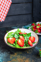 green salad strawberry leaves salad mix arugula, spinach organic healthy food meal snack copy space food background rustic. top view diet vegan or vegetarian food