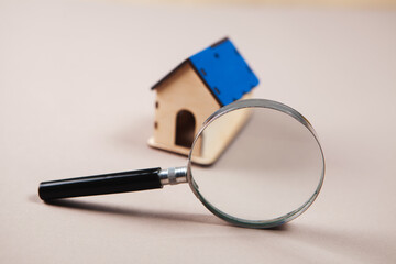 magnifying glass and house on the table. home search concept.