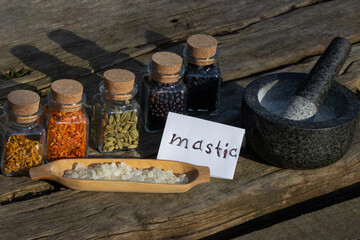 Mastic tears in wooden shell, mortar and pestle and a selection of botanicals in glasses.	