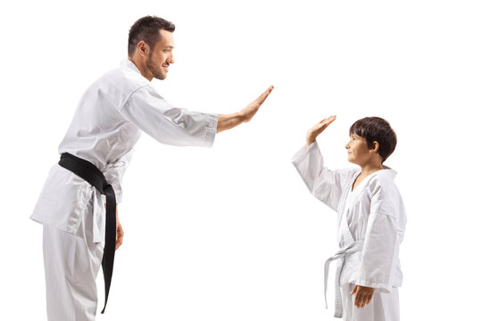 Child and man in karate kimonos gesturing high-five