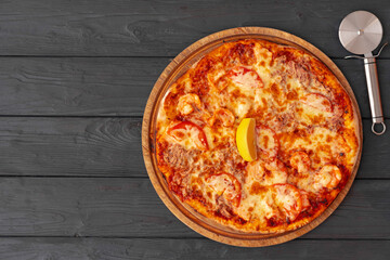 Tasty pizza on black wooden background top view