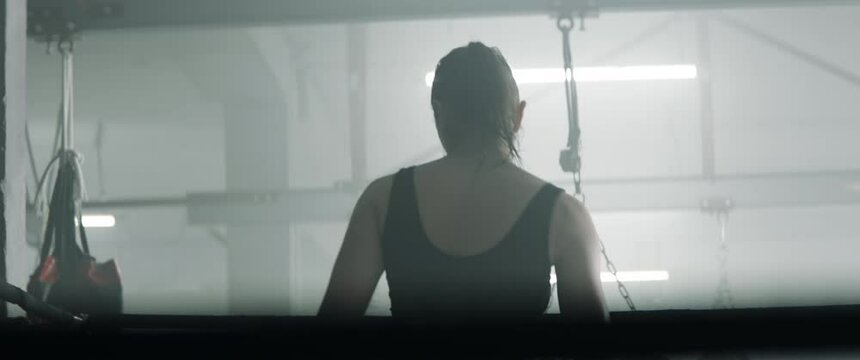 HANDHELD Caucasian female boxer fighter entering boxing ring before sparring fight. Shot with 2x anamorphic lens