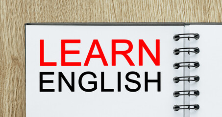 Notepad with text Learn ENGLISH on wooden deskt. study and education concept