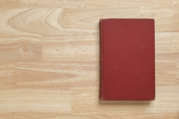 red hardcover book on wooden table for mockup blank template